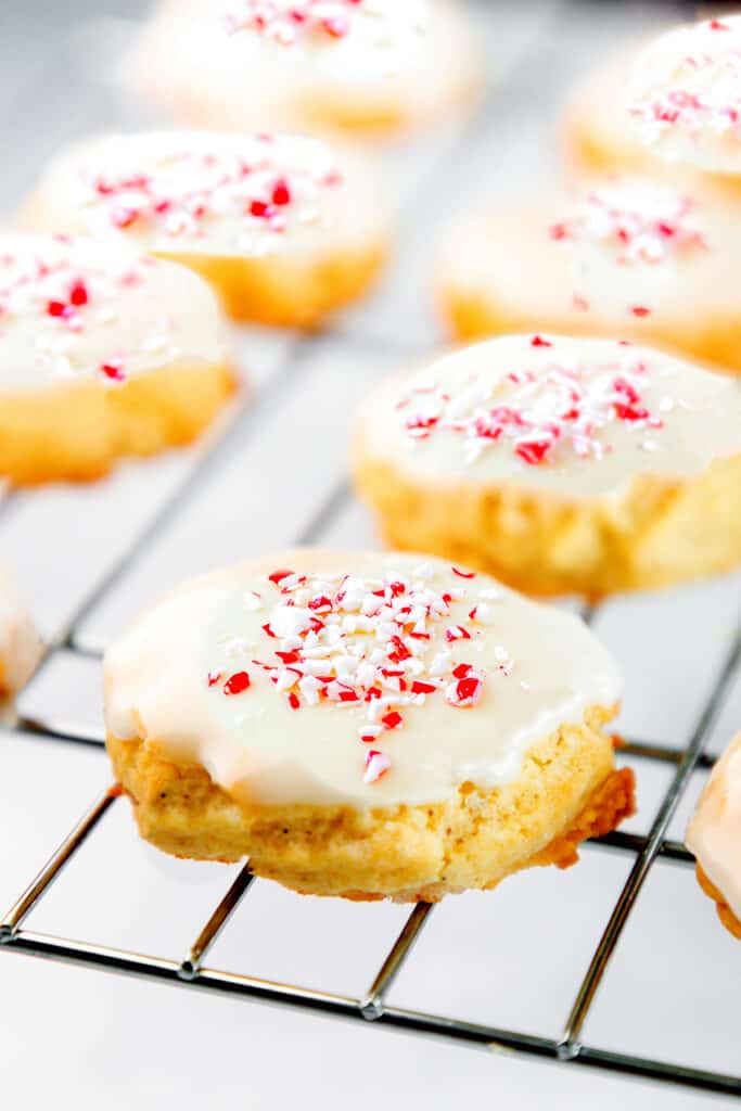 a batch of Soft sugar cookies with icing and crushed candy canes