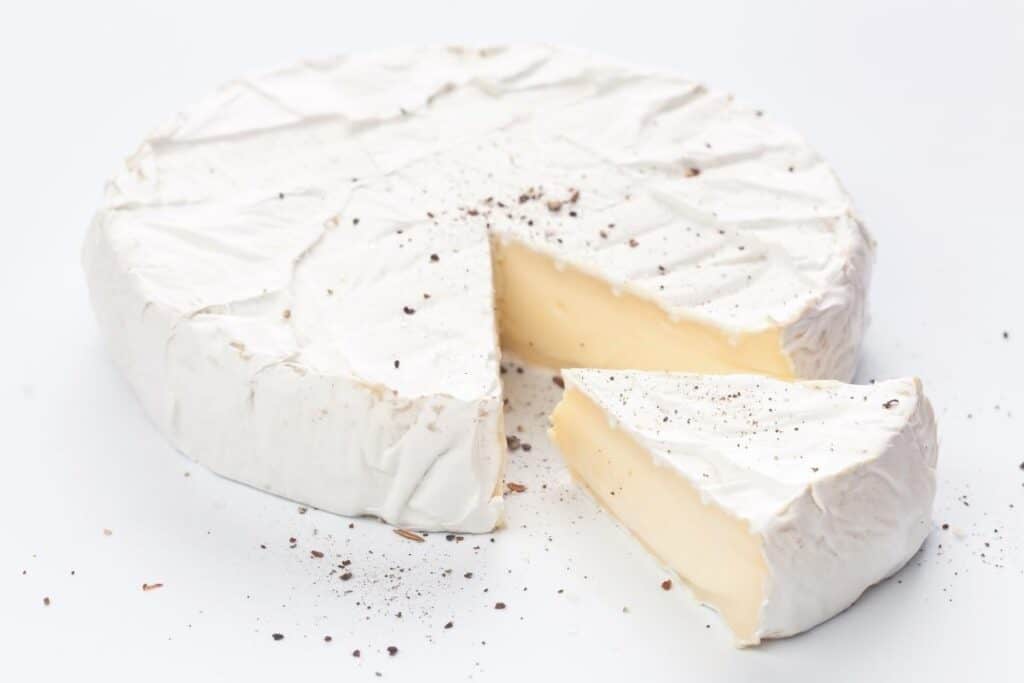brie cheese with a slice cut showing the creamy inside