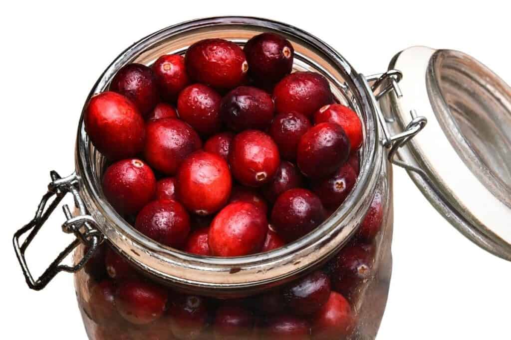 a glass mason jar filled with fresh cranberries