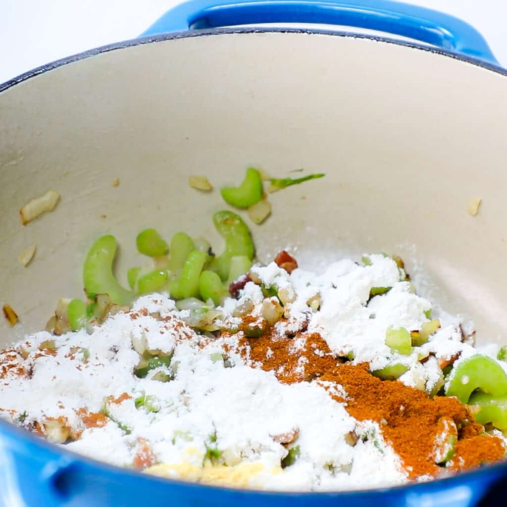 spices and flour added to the pan with the onion mixture