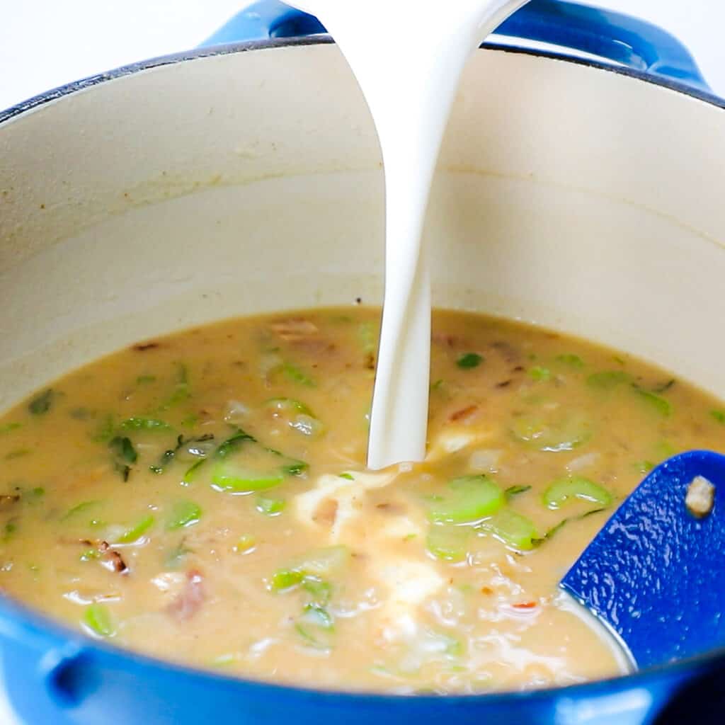 the cream being poured into the soup