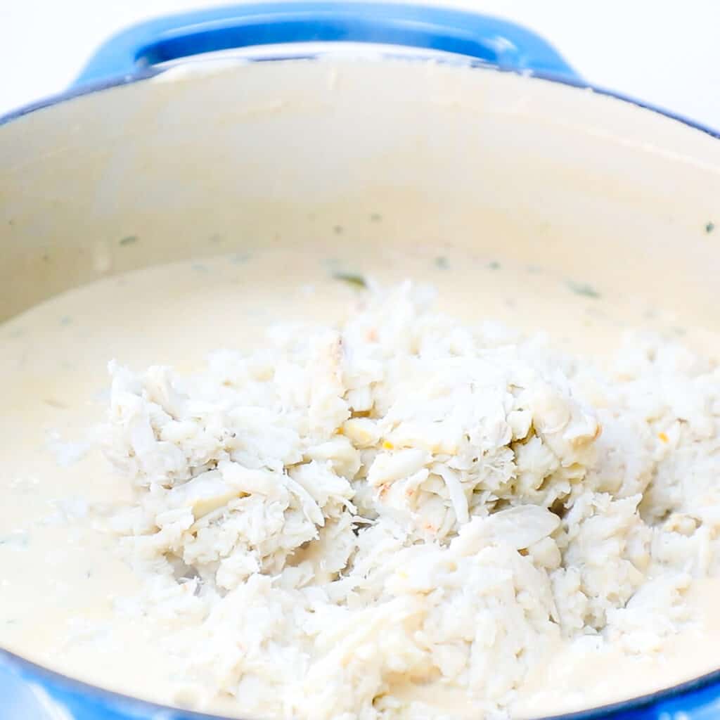 crab meat added to the soup in a stock pot