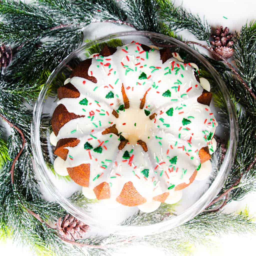an overhead image of a glazed  eggnog bundt cake with Christmas garland on the table