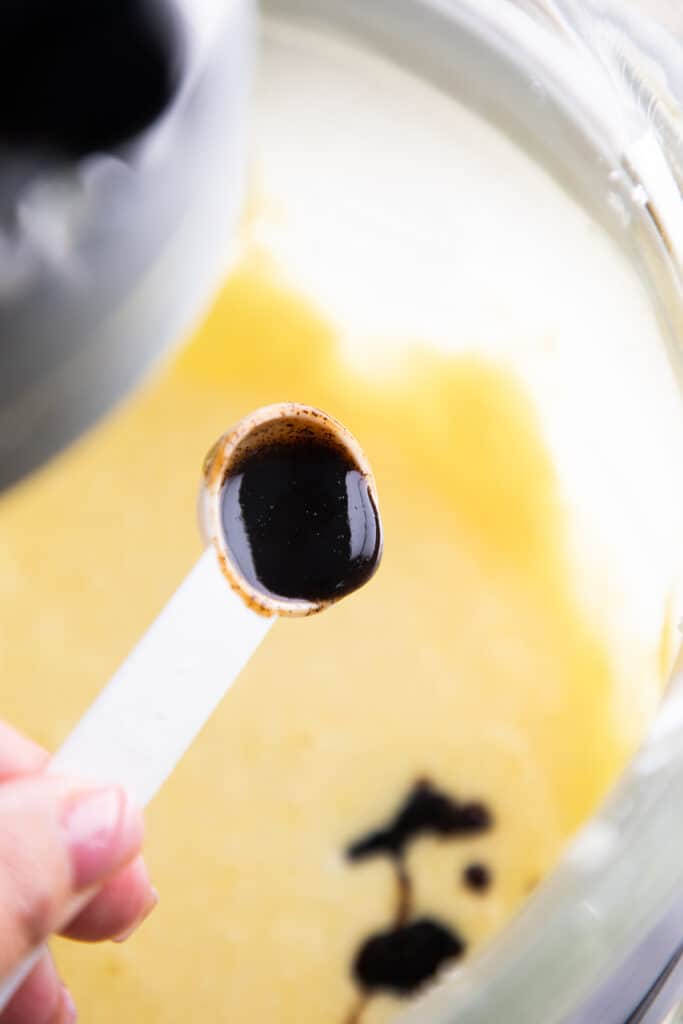 the vanilla bean paste being added to the butter mixture