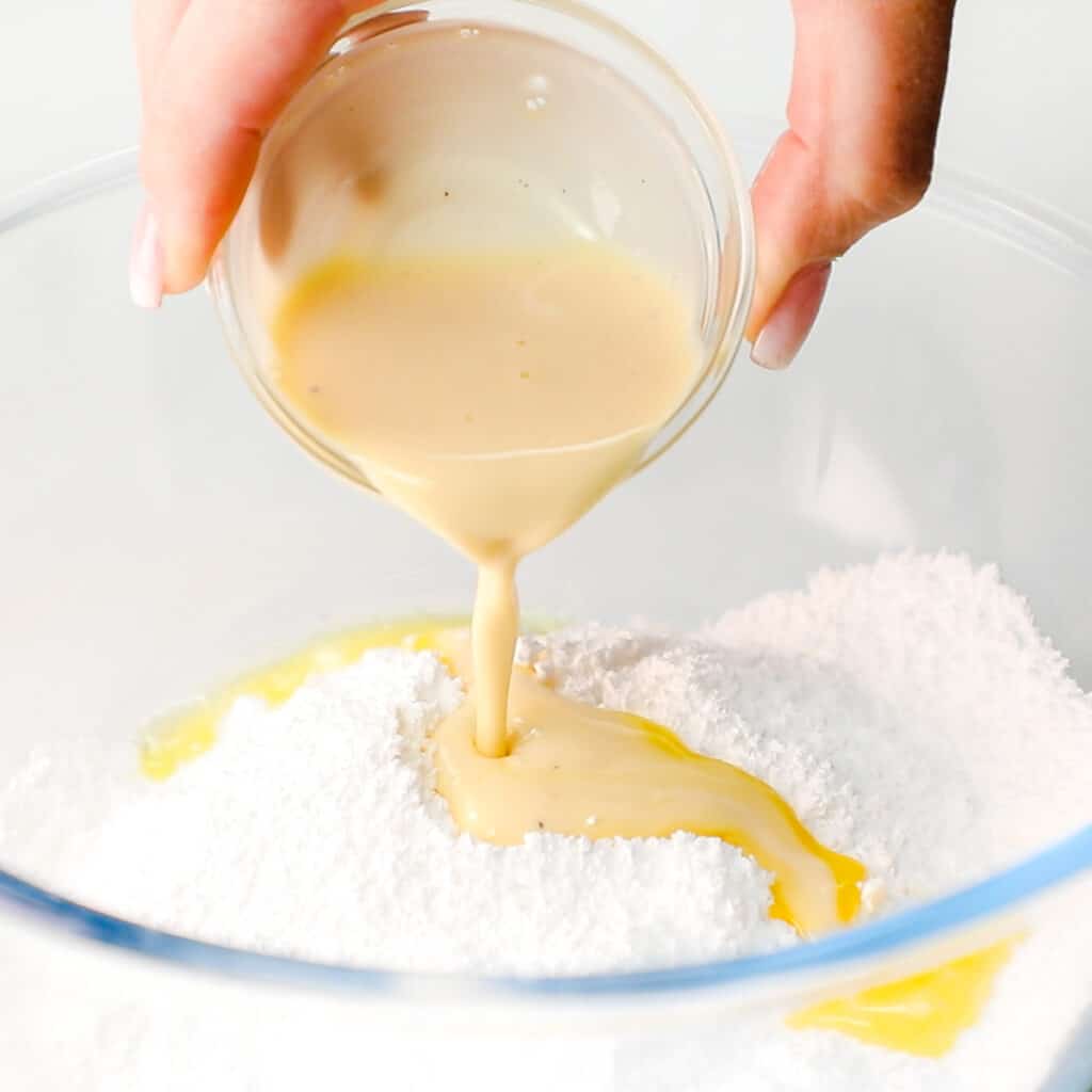 eggnog being poured into sugar in a bowl