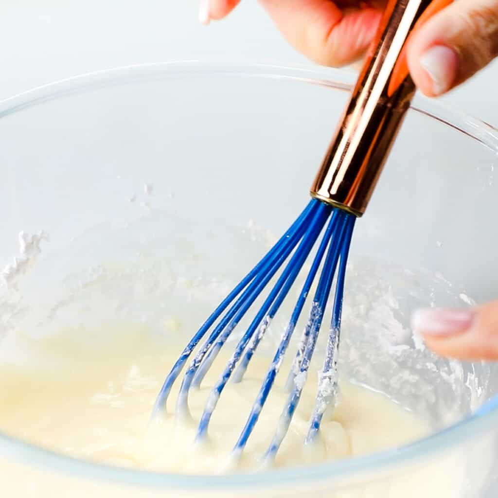 the mixed glaze in a bowl with a whisk