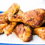 baked chicken leg drumsticks arranged on a white serving platter