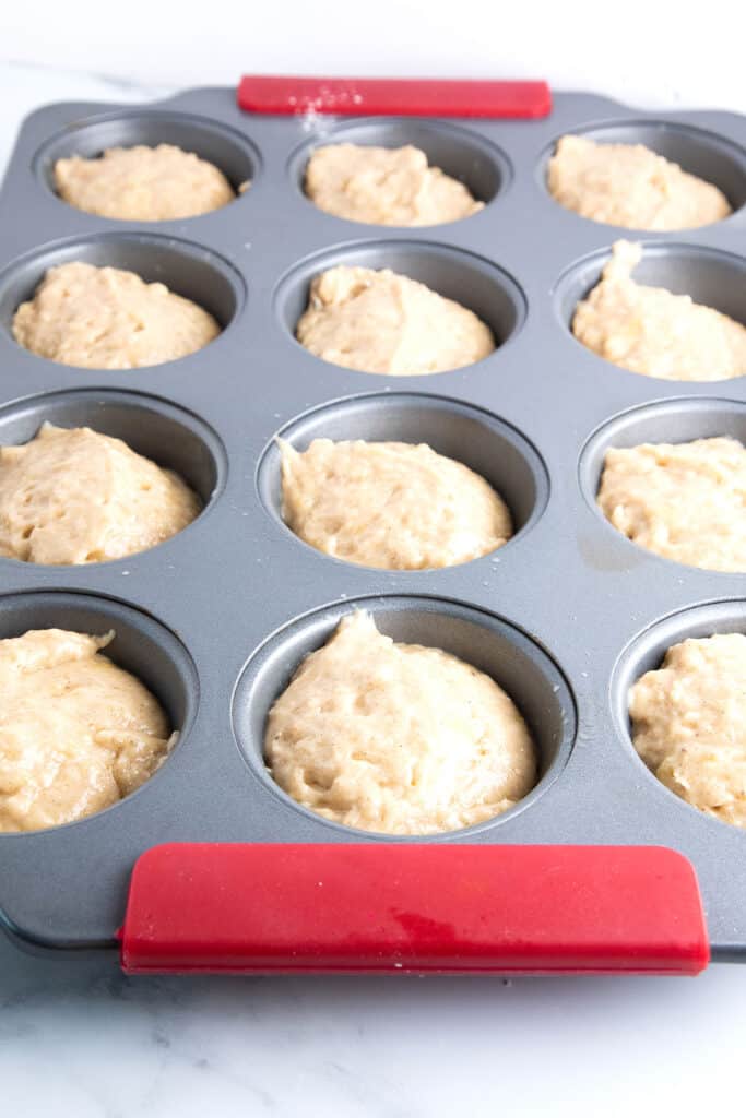 the batter for Cinnamon Banana Crumb Muffins in a muffin pan