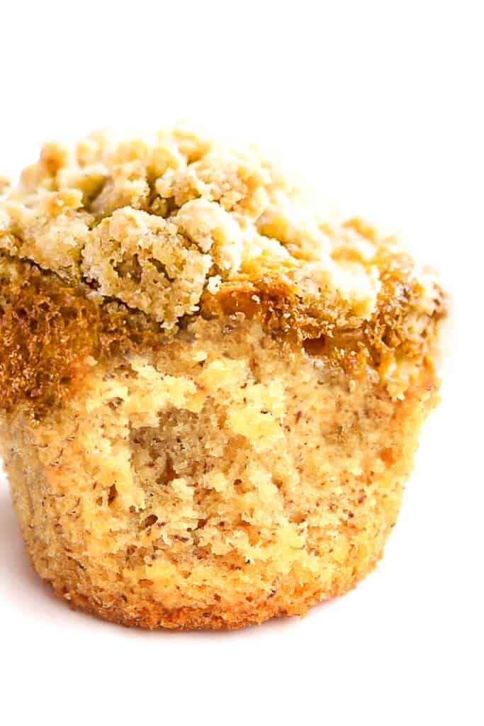a close up image of a Cinnamon Banana Crumb Muffin broken open to show the center