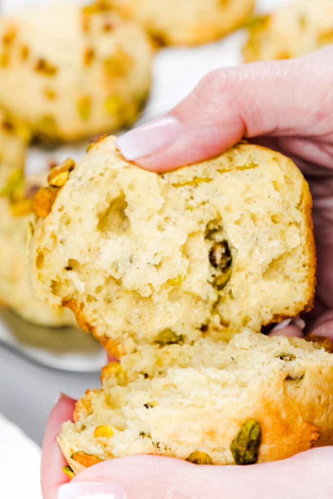 a woman holding a muffin that's just been broken open