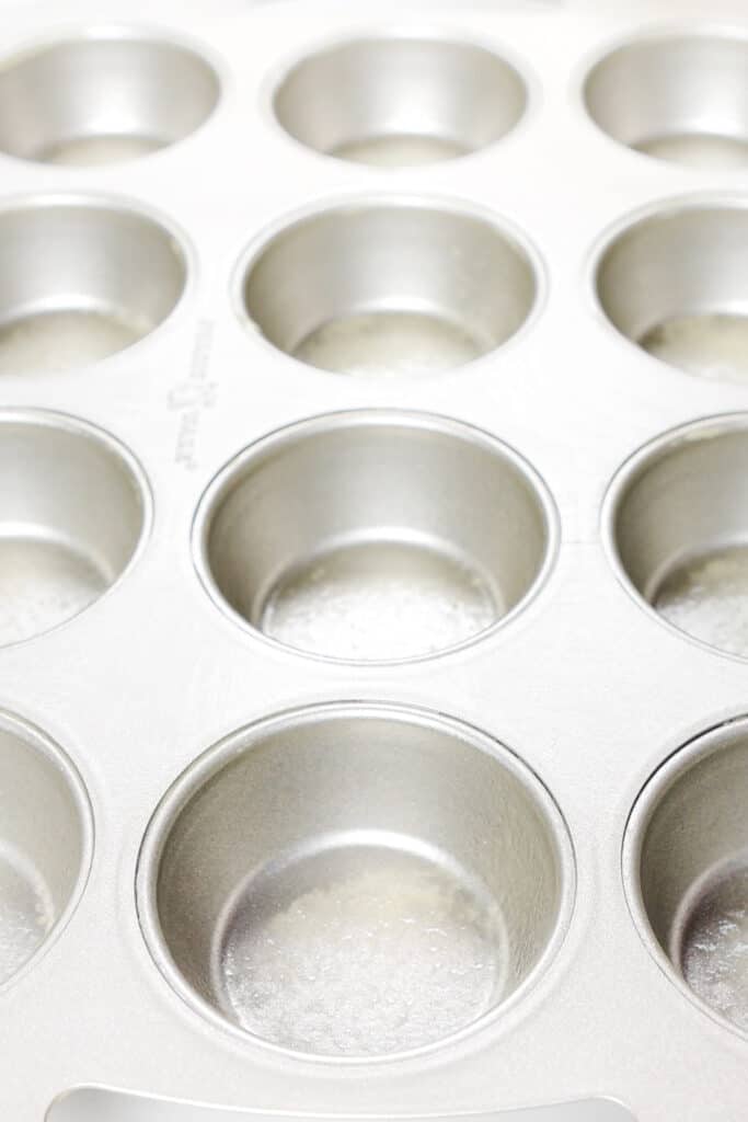 a muffin pan sprayed with baking spray