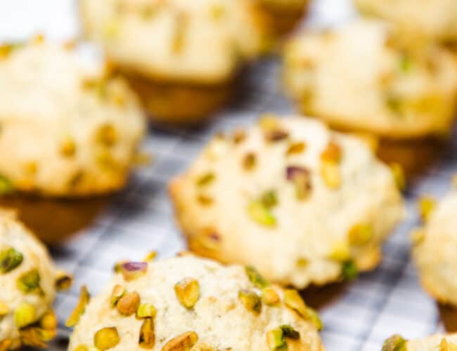 Pistachio Muffins topped with chopped pistachios on a cooling rack