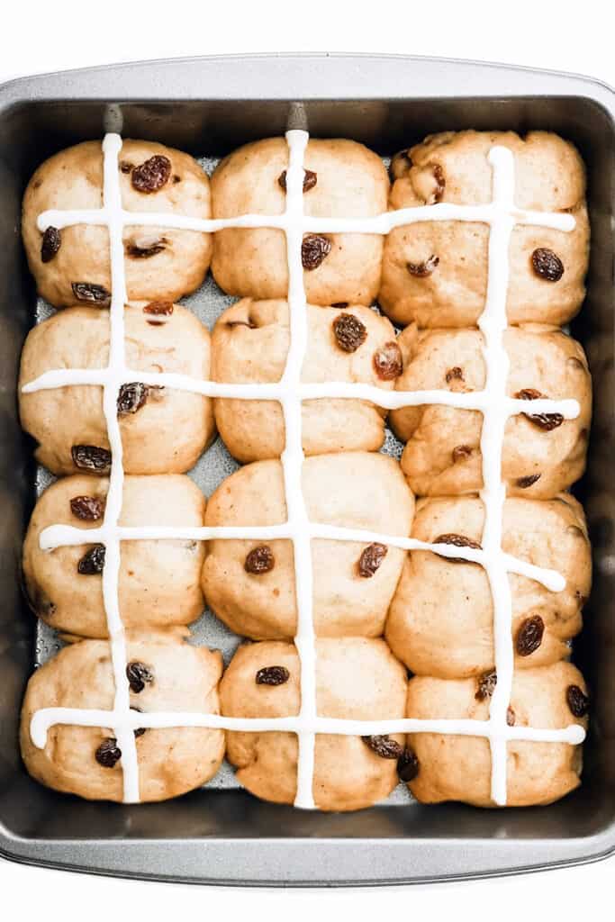 the hot cross buns dough in the pan piped with the cross