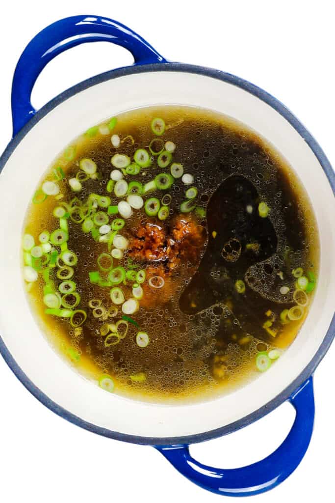 the miso paste, soy sauce, and green onions added to the pot