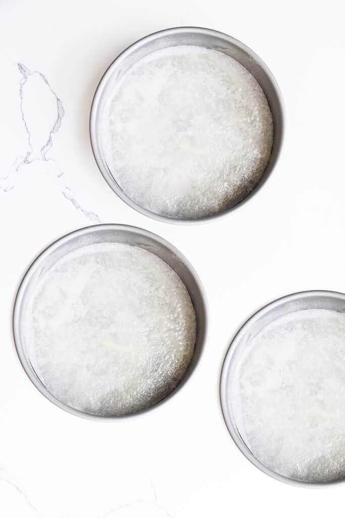 three round cake pans sprayed with baking spray