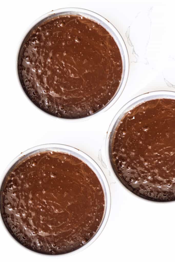 the cake batter in three round cake pans