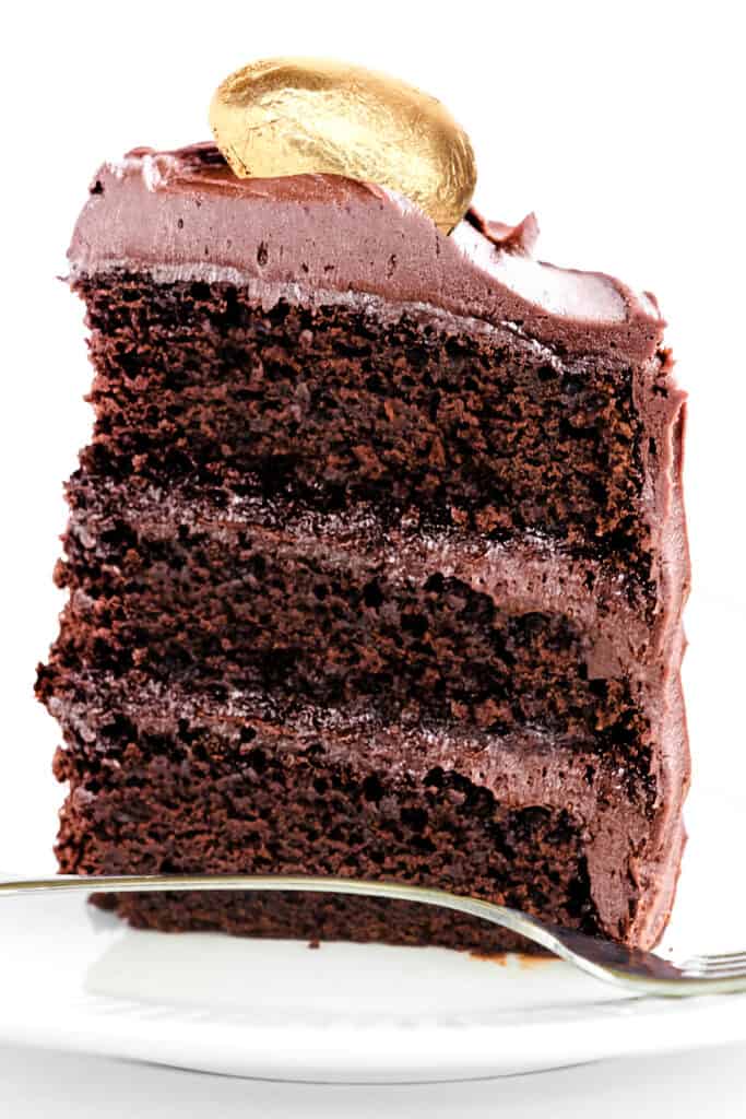 a slice of chocolate easter cake decorated with a chocolate egg wrapped in gold foil