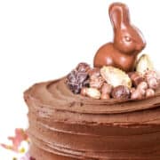 A vertical closeup shot of a chocolate cake decorated with flowers and easter candy