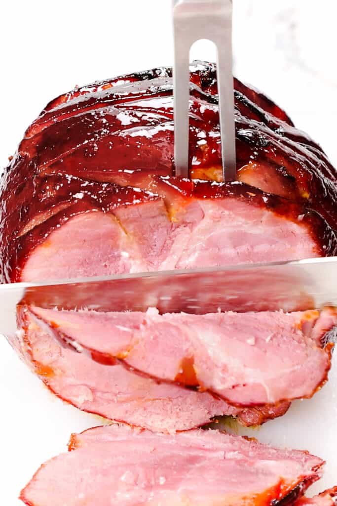 the Honey Glazed Ham being sliced with a knife