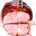 the Honey Glazed Ham being sliced with a knife
