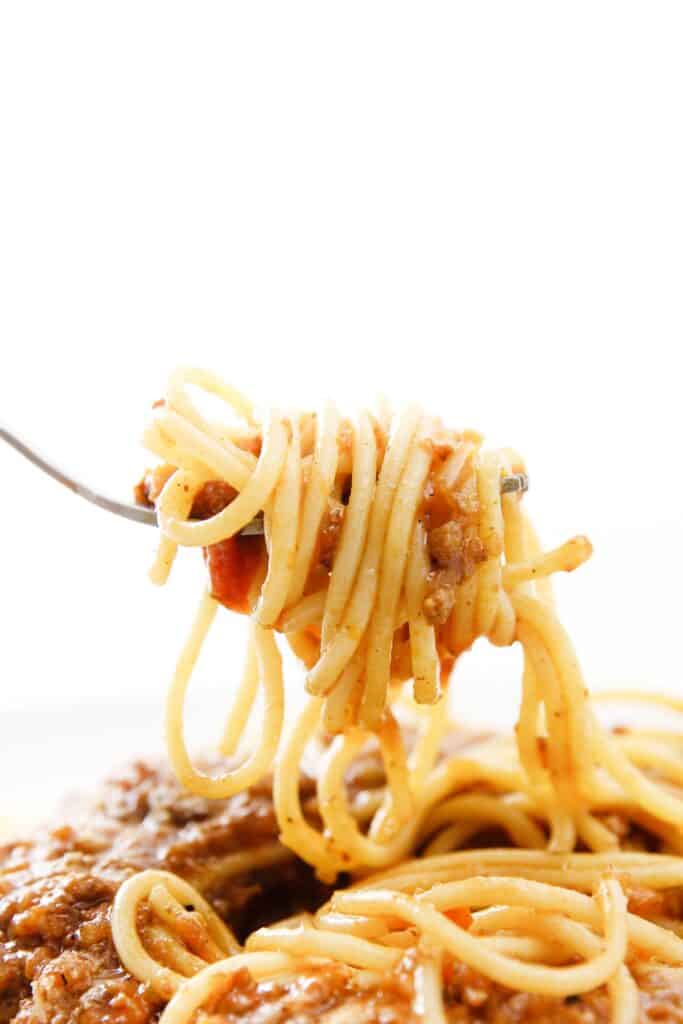 Spaghetti bolognese with fork isolated in white background