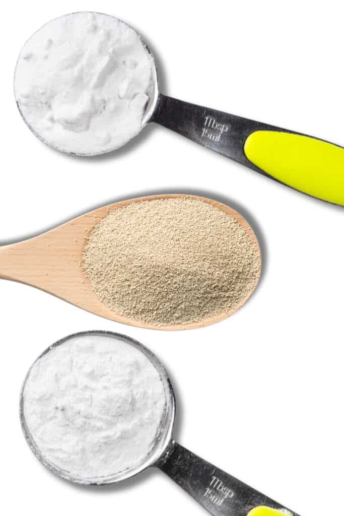 Three spoons with baking powder, baking soda, and dry yeast