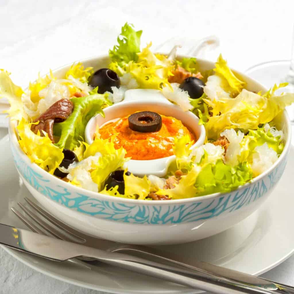 a bowl of Xatonada salad with a form and a knife