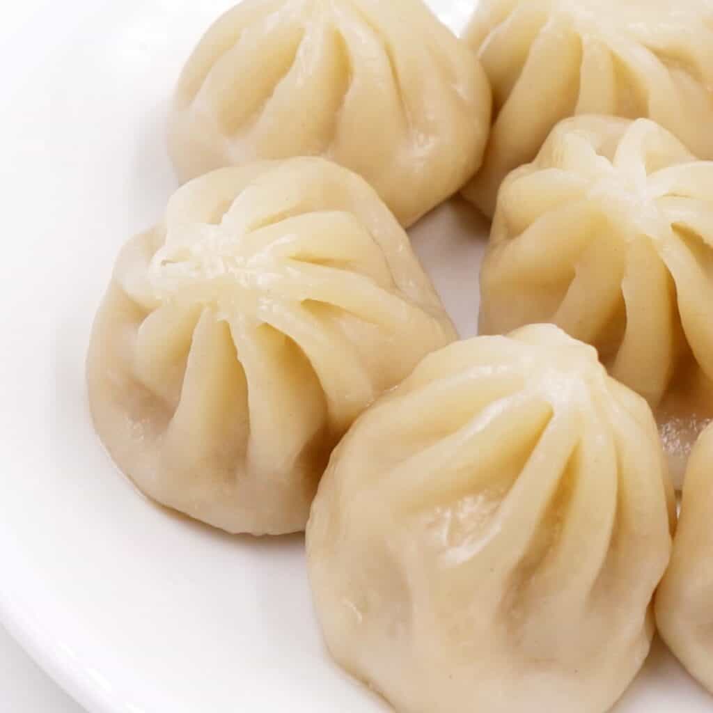 a dish of Xiao Long Bao on a white plate