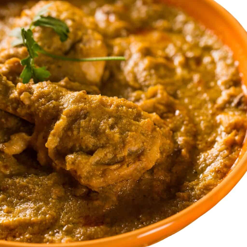 an orange bowl of chicken Xinxim de Galinha