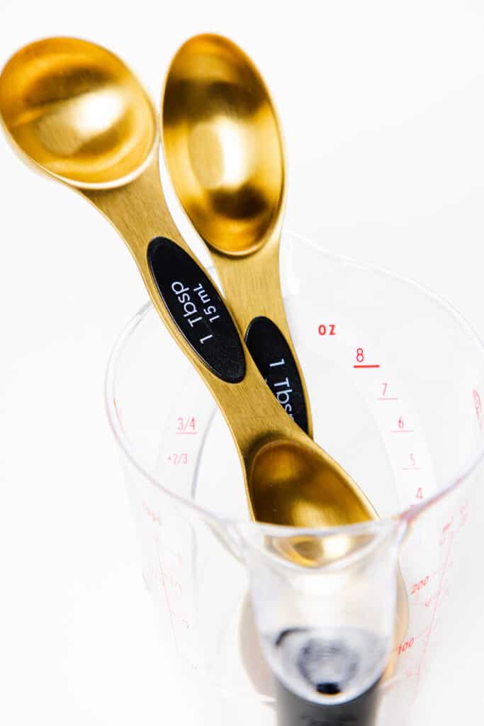 a photo of two different shaped tablespoons in a measuring cup