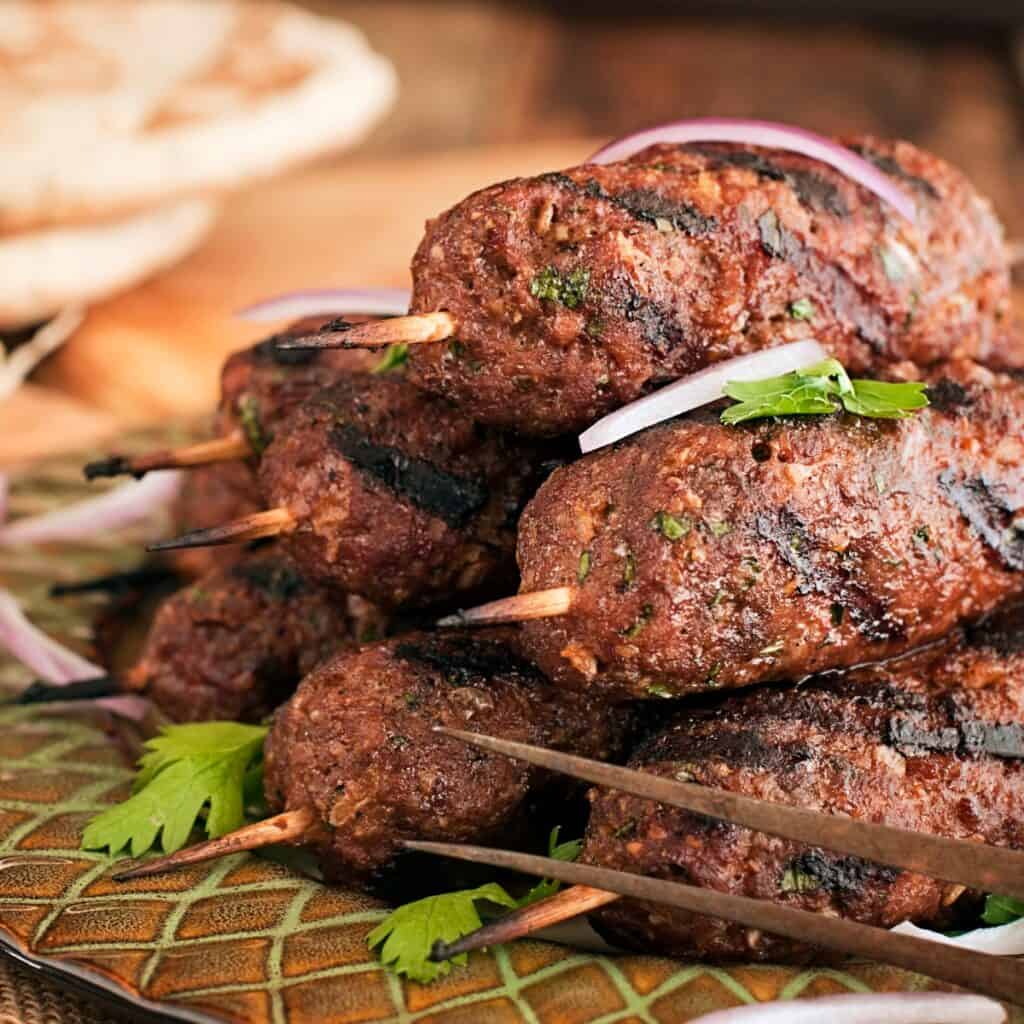 a pile of xinjiang lamb skewers of a plate