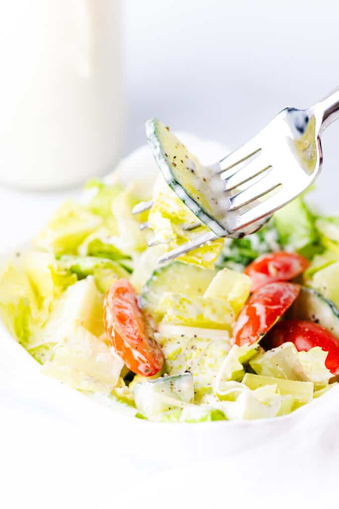 a green salad coated in a creamy garlic dressing