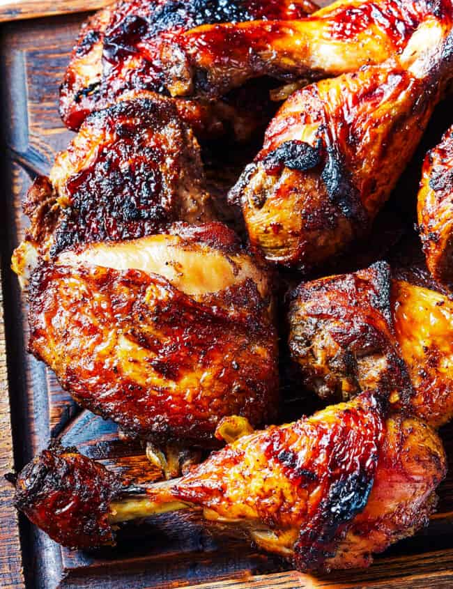 a wooden platter piled with Grilled Chicken Thighs & Legs