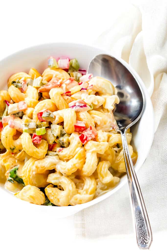 Amish Macaroni Salad in a bowl with a serving spoon.