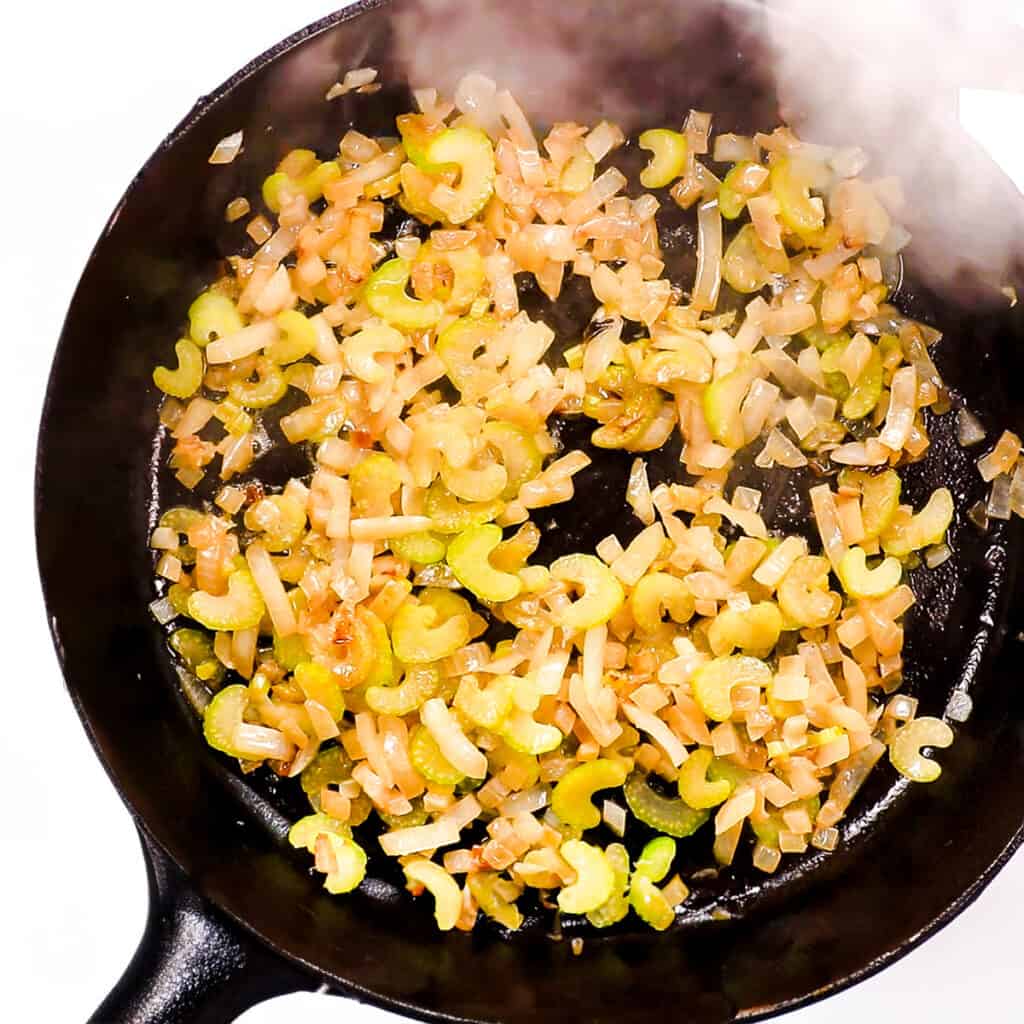 shallots, garlic, and celery for Saffron Risotto cooking in butter in a frying pan