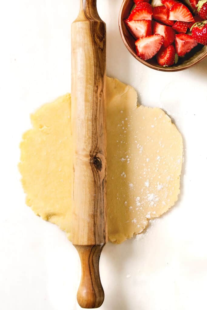 a rolled circle of puff pastry with a rolling pin