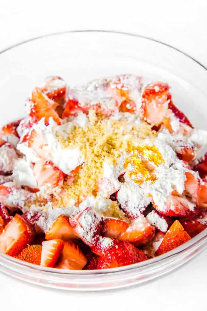 the strawberries in a bowl with the sugars, cornstarch, zest and orange juice.