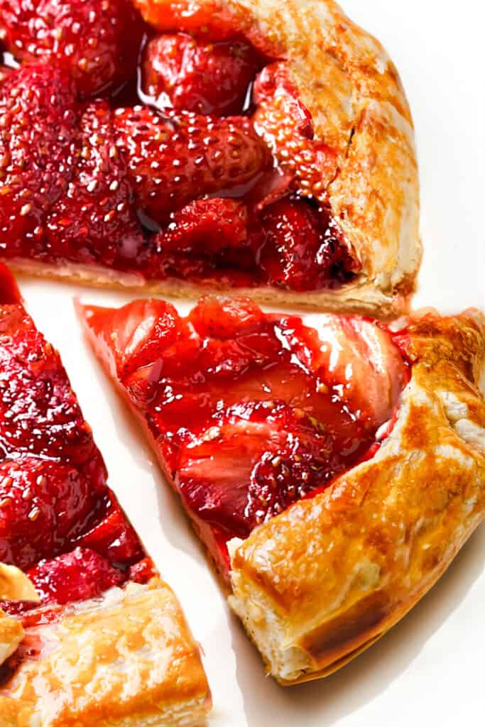 a close up image of a Strawberry Galette with a piece cut from it