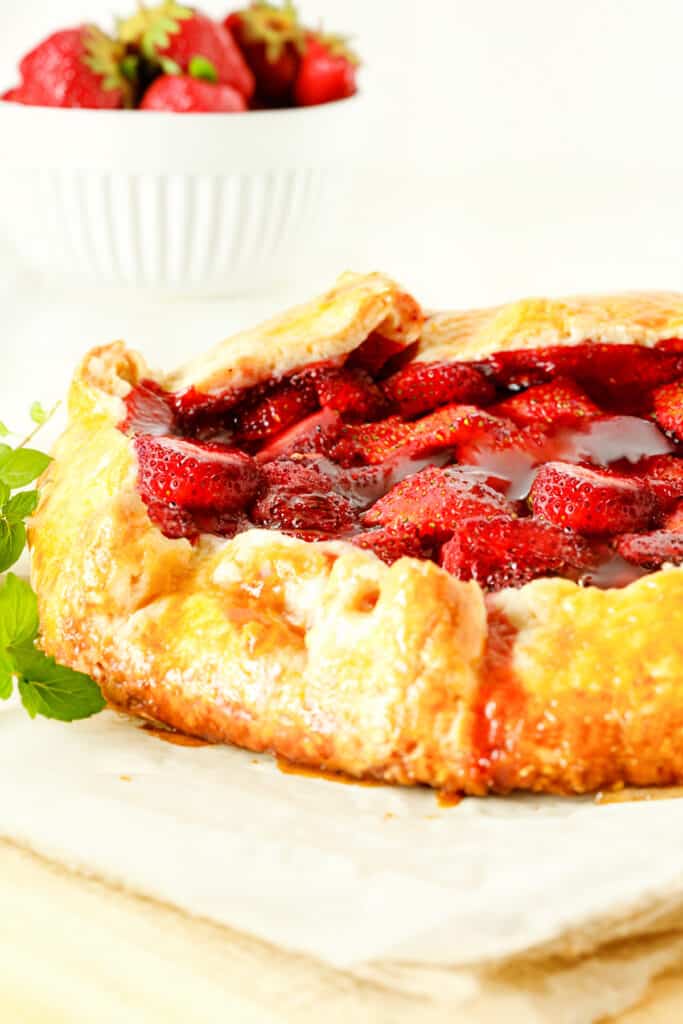 a close up image of a Strawberry Galette shot from the side to show the golden puff pastry crust.