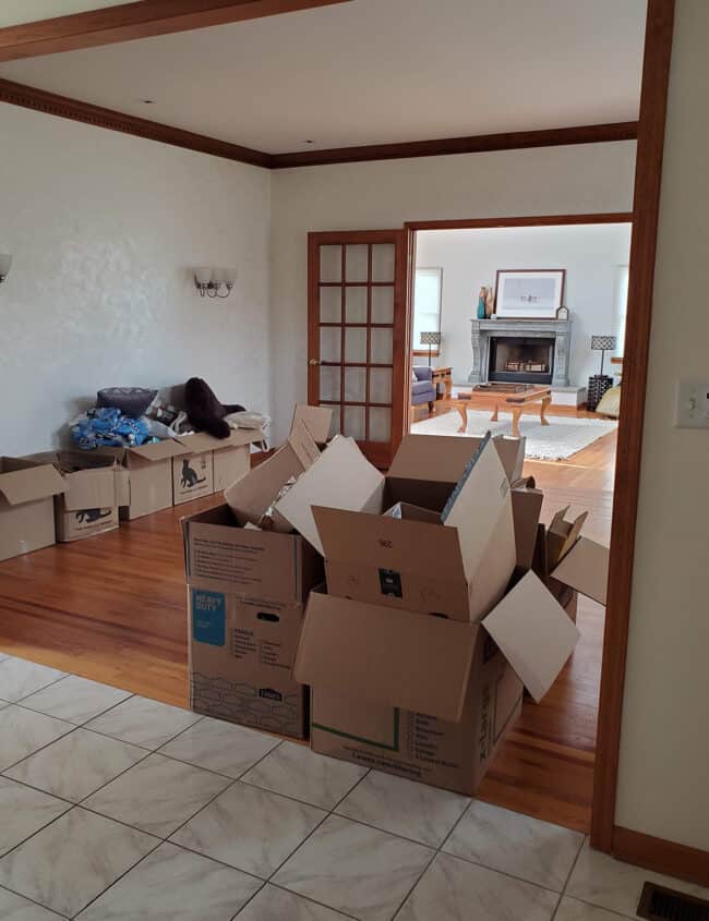 Moving boxes in a empty room with dated décor.