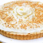 a full image of the coconut cream pie on a plate with a pie server next to it.