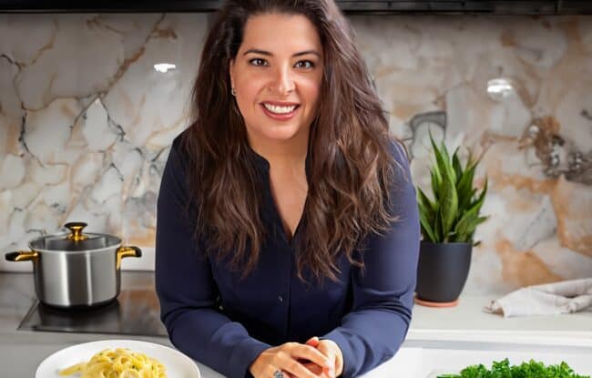 Erren hart of Erren's Kitchen leaning on a kitchen island.
