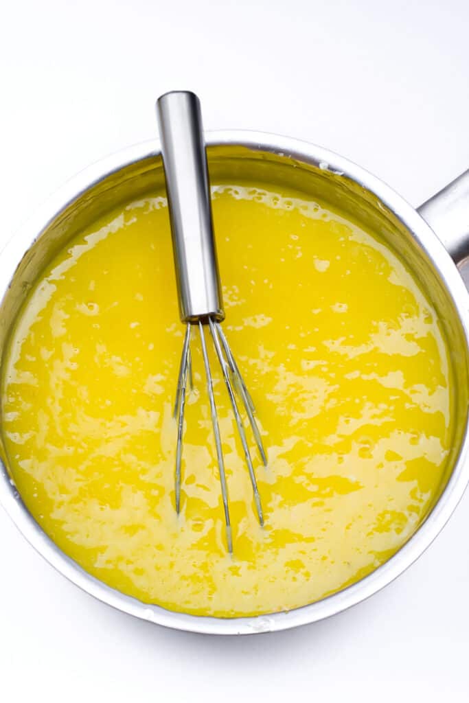 lemon curd cooking in a saucepan.