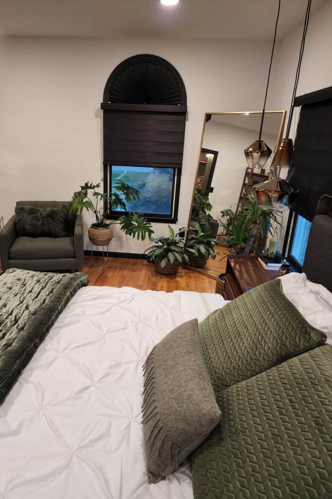 a bedroom with a large mirror and some plants