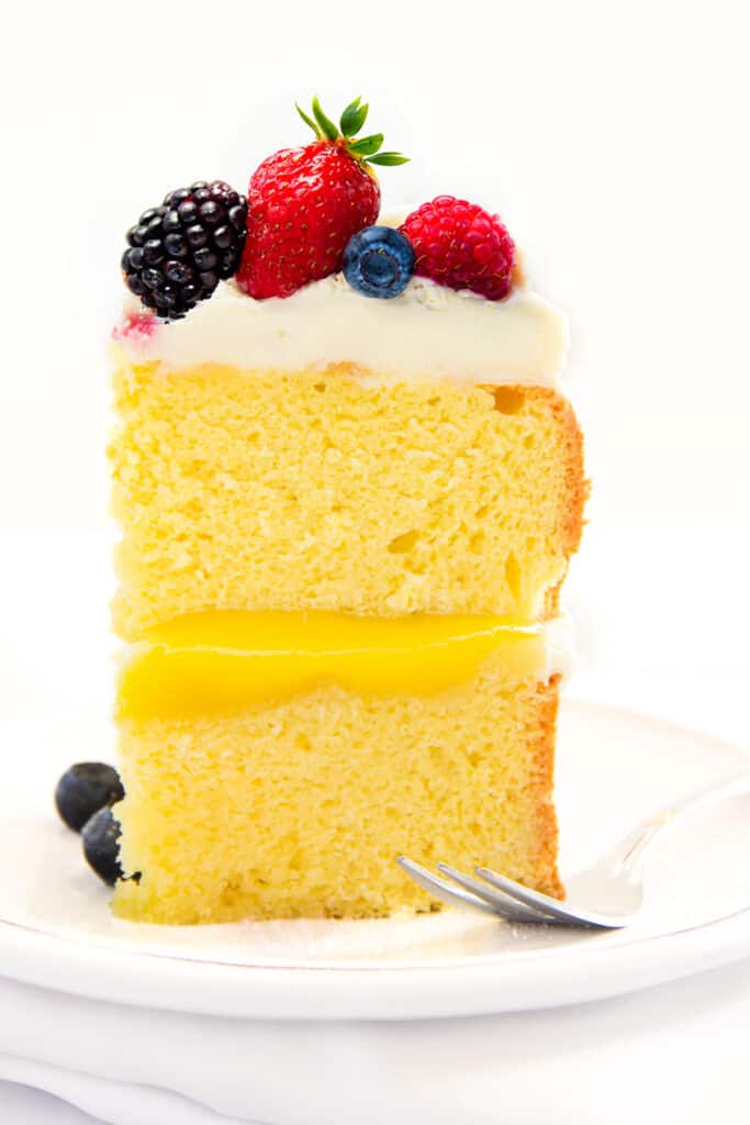 a slice of lemon curd cake topped with fruit.