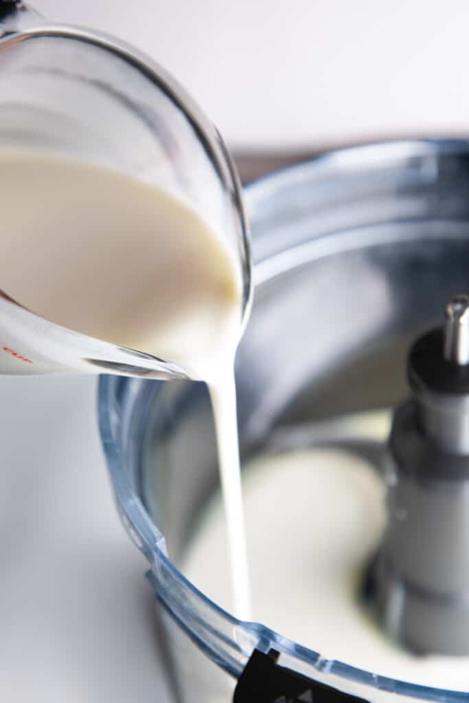 cream being poured into a mixer to make cookies and cream ice cream.