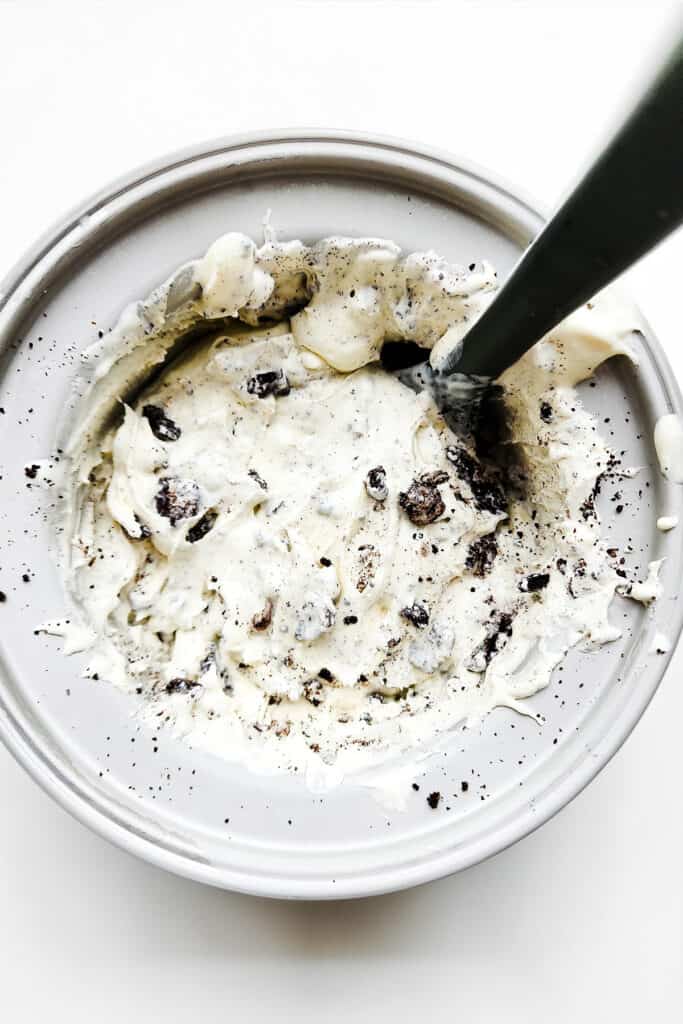 The crushed chocolate sandwich cookies added to the ice cream in the ice cream maker.