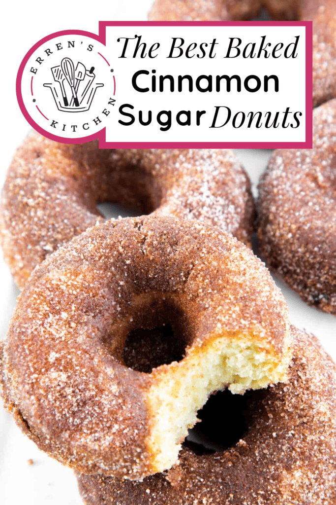 A pile of cinnamon sugar donuts. The top donut has a big bite taken out of it.