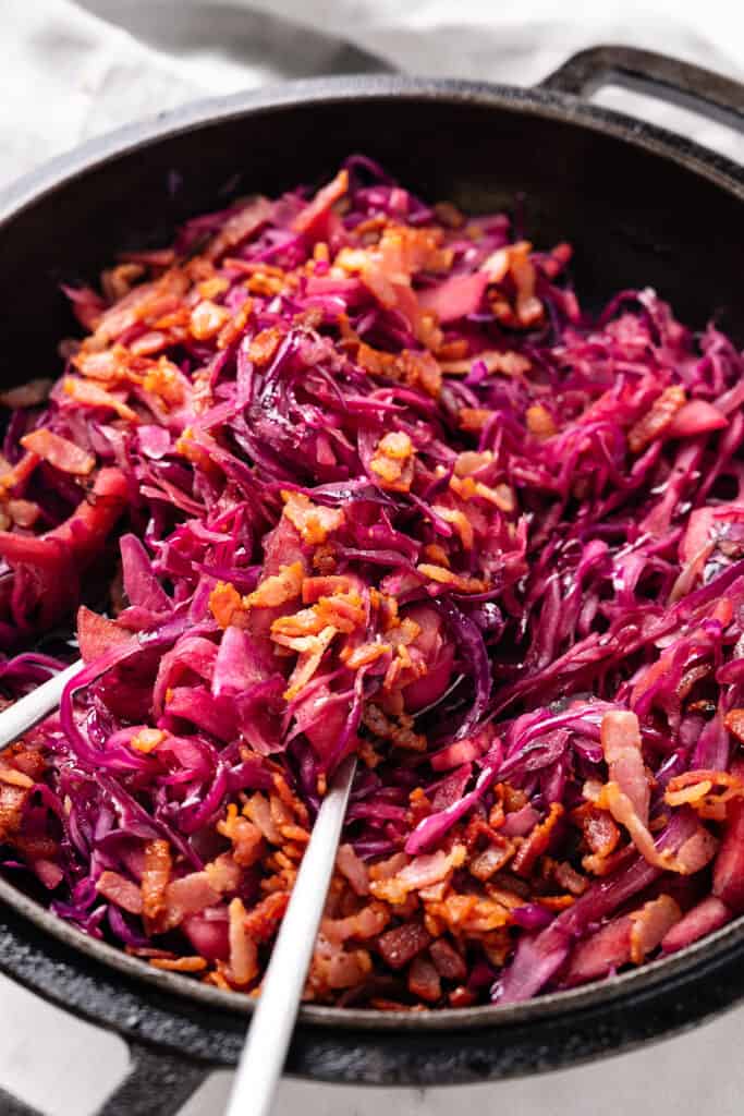 a close up image of braised cabbage scattered with crispy bacon.