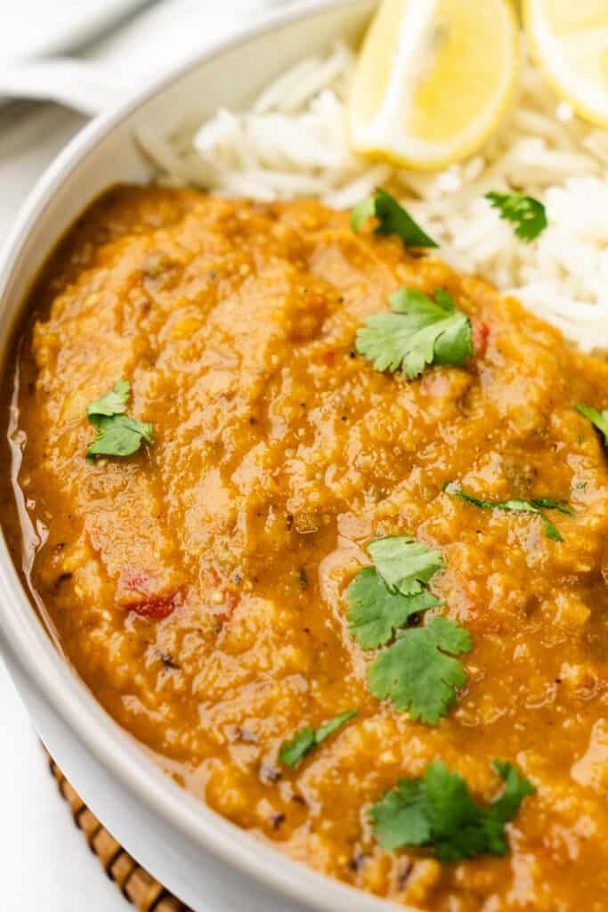 a close up image of Red Lentil Dahl Curry scattered with fresh cilantro leaves.